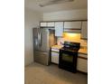 Bright kitchen featuring a stainless steel refrigerator and a black oven range at 6439 Cypressdale Dr # 202, Riverview, FL 33578