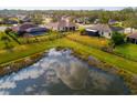 Peaceful backyard pond view surrounded by lush landscaping and verdant grass at 7304 63Rd E Ct, Palmetto, FL 34221