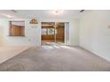 Bright living room with carpet floors and sliding glass doors leading to outdoor area at 9121 Prosperity Ln, Port Richey, FL 34668