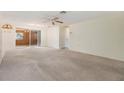 Spacious living room with ceiling fan and neutral carpet, ready for personalization at 9121 Prosperity Ln, Port Richey, FL 34668