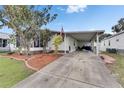 This home features a covered carport, an American flag, and a well manicured lawn at 9417 Star Gazer Ln, Riverview, FL 33578