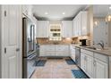 Well-lit kitchen with stainless steel appliances, tiled backsplash, white cabinets, and a window above the sink at 11309 Callisia Dr, Odessa, FL 33556