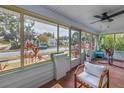 The screened-in porch showcases outdoor living with a chair and views of lush greenery and the neighborhood at 1155 23Rd N Ave, St Petersburg, FL 33704