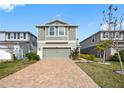 Inviting two-story home with gray siding and a brick driveway, offering a charming curb appeal at 11616 Little River Way, Parrish, FL 34219