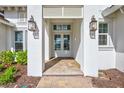 Close up of the front door entrance with brick pavers and decorative lanterns at 1201 Blue Shell Loop, Sarasota, FL 34240