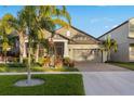 Attractive 1 story house with screened porch, palm trees, and a landscaped yard at 13634 Ashlar Slate Pl, Riverview, FL 33579