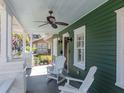 Inviting front porch featuring rocking chairs, fan, sconces, and a painted green ceiling at 1405 Nance Ave, Tampa, FL 33606