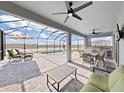 Covered patio with pool and outdoor kitchen overlooking a lake at 2302 Village Amble Loop, Lutz, FL 33558