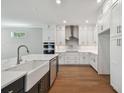 Modern kitchen with white cabinets, stainless steel appliances, and a large center island at 3022 W Cass St, Tampa, FL 33609