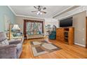 Cozy living room featuring laminate flooring, neutral paint, a ceiling fan and large windows at 34051 Kiefer Rd, Dade City, FL 33525