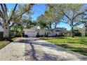 One-story home with a brick facade, a well-maintained lawn, and mature trees and landscaping at 3621 S Belcher Dr, Tampa, FL 33629