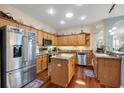 Bright kitchen features stainless steel appliances, an island, and beautiful hardwood floors at 5718 Heronpark Pl, Lithia, FL 33547