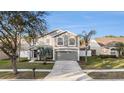 Two story home with a gray exterior, lush lawn, and a palm tree in the front yard at 5914 Falconwood Pl, Lithia, FL 33547