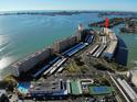 Aerial view of waterfront condo complex featuring a swimming pool and tennis courts at 6075 Shore S Blvd # 605, Gulfport, FL 33707