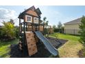 Backyard wooden playground features a slide, climbing wall, and a swing at 6135 Voyagers Pl, Apollo Beach, FL 33572