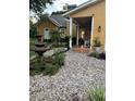 Landscaped front yard with a stone water fountain and a variety of plants at 11545 Kent Grove Dr, Spring Hill, FL 34610