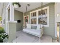 Inviting front porch with a swing, decorative plants, and charming details, creating a relaxing outdoor space at 1211 E Giddens Ave, Tampa, FL 33603