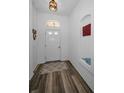 Bright entryway featuring wood-look flooring, a decorative niche, and a transom window above the door at 12141 Arron Ter, Trinity, FL 34655