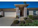 Inviting front entrance with brick columns, a covered porch, and manicured landscaping at 12141 Arron Ter, Trinity, FL 34655