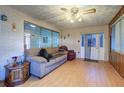 Living room with light wood floors, a sofa, and brick walls at 1235 45Th N St, St Petersburg, FL 33713