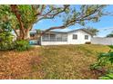 Spacious backyard with a screened-in porch area, and a mature shade tree at 14005 Leeward Dr, Seminole, FL 33776