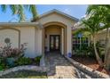 Inviting front entrance with double doors, a stone pathway, and colorful landscaping at 1509 Ventana Dr, Sun City Center, FL 33573