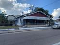 Street-level view of home with mature tree, chain link fence, and overcast sky at 3208 N 15Th St, Tampa, FL 33605