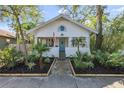 Inviting white bungalow with blue door, mature landscaping, and stone walkway at 468 11Th N Ave, St Petersburg, FL 33701