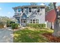 Two-story gray house with a white door, landscaping, and a driveway at 5714 S 1St St, Tampa, FL 33611