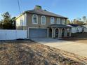 View of the two-story home with arched windows, two-car garage, and a long driveway at 6113 Freeport Dr, Spring Hill, FL 34606