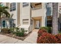 Close-up of condo entrance showing unit numbers, trimmed bushes, and front door at 6171 Bahia Del Mar Blvd # 116, St Petersburg, FL 33715