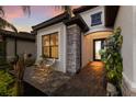 Charming front entrance with stone accents, an outdoor seating area, and a beautifully paved walkway at 706 Acacia Ct, Bradenton, FL 34212