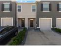 Townhome exterior showcasing a well-manicured lawn, garages, and coordinated facade paint at 8617 Falling Blue Pl, Riverview, FL 33578