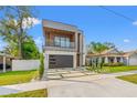 Eye-catching modern home boasting clean lines, a balcony, and a well-maintained lawn at 910 W West St, Tampa, FL 33602