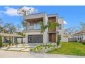 Beautiful modern home with a balcony, wood accents, manicured landscaping and modern driveway at 910 W West St, Tampa, FL 33602