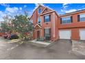 Townhome featuring neutral stucco exterior, single car garage and mature trees at 9142 Lake Chase Island Way # 9142, Tampa, FL 33626