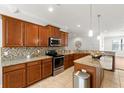 Spacious kitchen featuring granite countertops, stainless steel appliances, and classic wood cabinets at 10063 Celtic Ash Dr, Ruskin, FL 33573