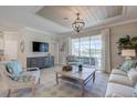 Well-lit living room with stylish furnishings, a ceiling design feature, and a view to the outdoor patio at 11297 Pinot Dr, Venice, FL 34293