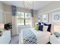 Bright bedroom with a decorative accent wall, a large window, and elegant furnishings at 11393 Pinot Dr, Venice, FL 34293