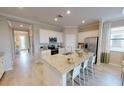 Modern kitchen featuring a large island with a granite countertop, stainless steel appliances, and white cabinetry at 11393 Pinot Dr, Venice, FL 34293