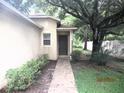 Inviting front entrance with a covered porch, lush greenery, and a walkway leading to the front door at 11818 Mango Groves Blvd, Seffner, FL 33584