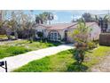 Charming bungalow with a red tile roof, arched window, and well-manicured lawn at 15732 1St E St, Redington Beach, FL 33708