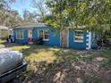 Side angle view of the blue home showing the yard, windows and front door at 1911 E Noel St, Tampa, FL 33610