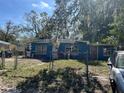 Full front exterior view of the blue single-story home with a yard in need of care at 1911 E Noel St, Tampa, FL 33610