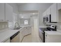 Well-lit kitchen featuring white cabinets, modern appliances, and tile flooring at 2333 Appaloosa Cir, Sarasota, FL 34240