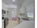 Bright kitchen with white cabinetry, tile floor, stainless appliances, and a view into the dining area at 2333 Appaloosa Cir, Sarasota, FL 34240