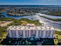 Aerial view of a waterfront condominium building featuring balconies and water views at 4516 Seagull Dr # 405, New Port Richey, FL 34652