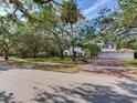 Stately home featuring a brick driveway and a three-car garage, all nestled among mature trees at 5001 S Shore Crest Cir, Tampa, FL 33609