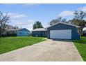 Front view of a charming blue house with a white garage door at 7353 Knoll Dr, New Port Richey, FL 34653