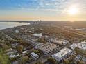 Wide aerial shot of cityscape, showcasing a complex with surrounding buildings, trees, and a view of the sea at 800 S Dakota Ave # 205, Tampa, FL 33606